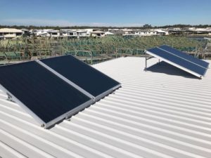 Solar hot water system panels mounted on a metal roof in Maroochydore
